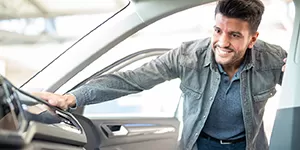 Guy looking at an auto for sale.