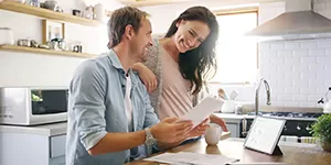 Couple in kitchen looking at a paper