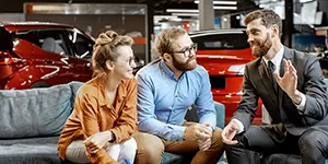 people talking at an auto dealership