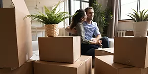 Couple in a home with packing boxes in the foreground.